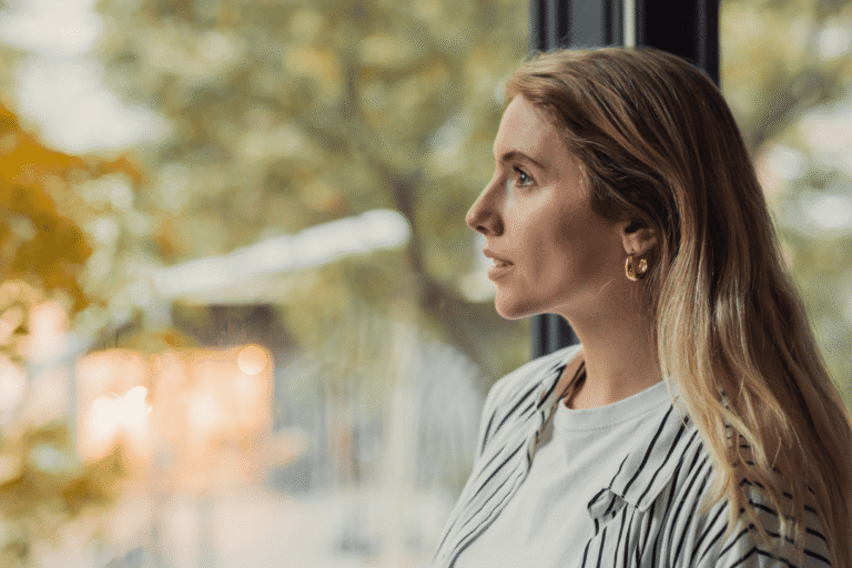 Woman looking out of window pensively