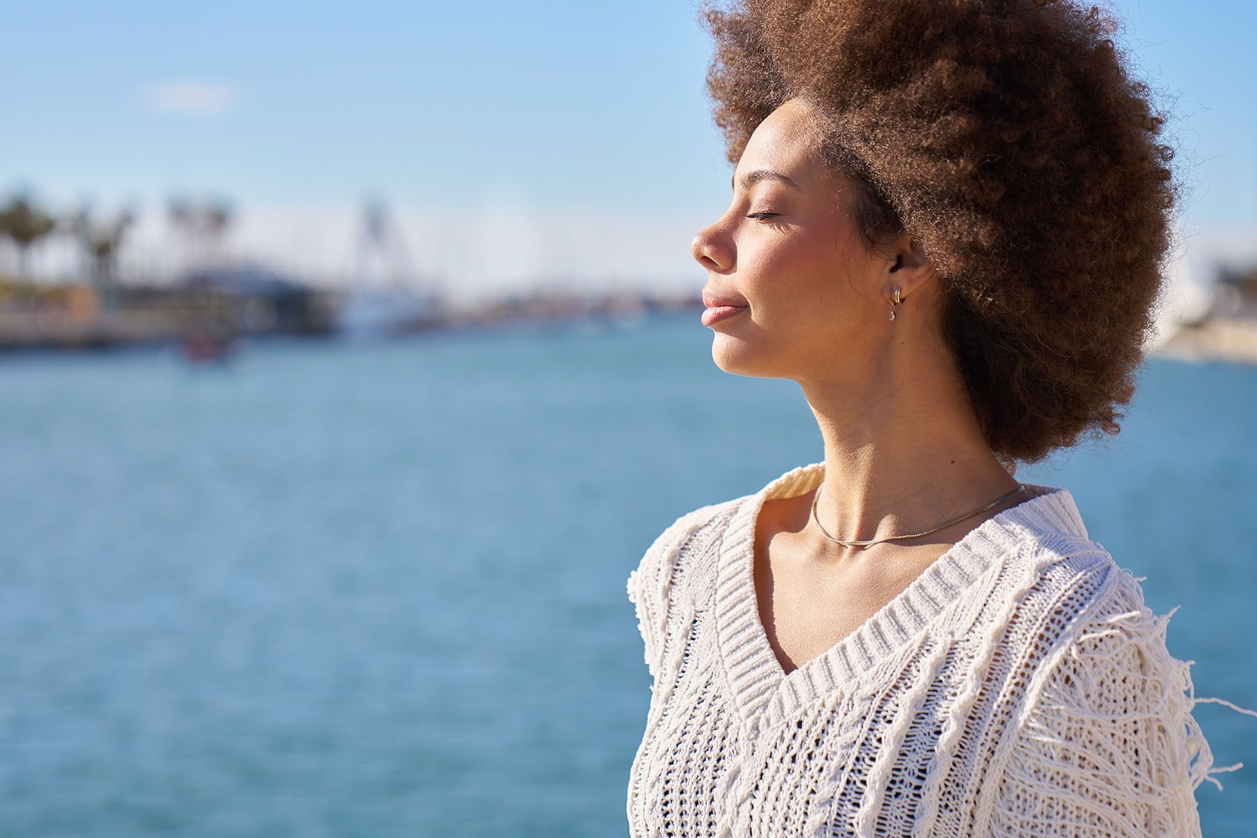 a-woman-with-curly-hair-is-standing-on-a-pier-over-2026-01-06-09-00-39-utc
