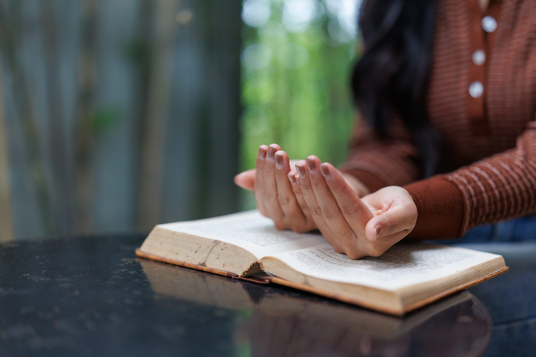 woman-praying-with-open-holy-book-on-table-2025-10-08-12-28-48-utc
